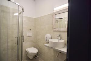 a bathroom with a toilet and a sink and a shower at Süni Vendégház in Căpîlniţa