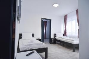 a room with two beds and a mirror at Süni Vendégház in Căpîlniţa