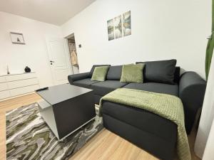 a living room with a couch and a table at Cozy green apartament in Mediaş