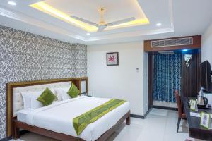 1 dormitorio con 1 cama y TV en Treebo Trend Empire, en Vijayawāda