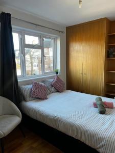 a bedroom with a bed with pillows and a window at Urban Snooze in Herne Hill