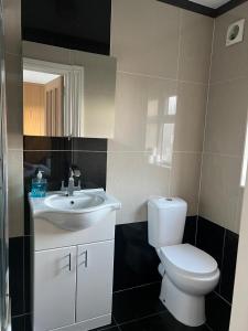 a bathroom with a white toilet and a sink at Urban Snooze in Herne Hill