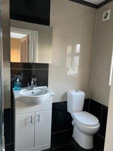 a bathroom with a white toilet and a sink at Urban Snooze in Herne Hill