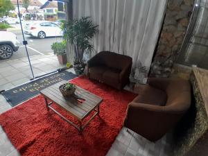 a living room with two chairs and a coffee table at Casa de Pedra Mineira in Canela