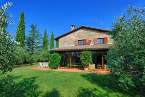 une grande maison en pierre dans une cour arborée dans l'établissement Holiday Home Casale Giulio by PosarelliVillas, à Cetona