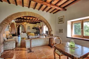 sala de estar con mesa y arco en Holiday Home Casale Giulio by PosarelliVillas, en Cetona