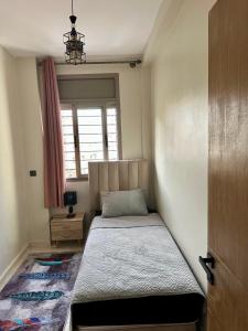 a bed in a room with a window at Séjour Confort clim Navette Aéroport in Salé