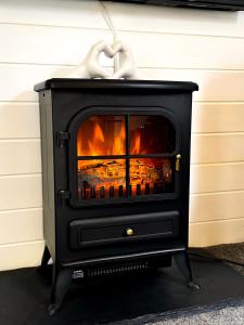 a black stove with a heart on top of it at Boann 5 - Hot Tub-Hunting Tower Lodges-Luxury-Families-Romantic in Perth