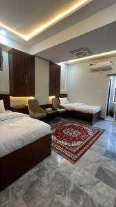a hotel room with a bed and a living room at Hotel Araamish in Peshawar