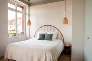 a bedroom with a white bed with two pillows at Villa Chantereine in Cabourg +88 photos