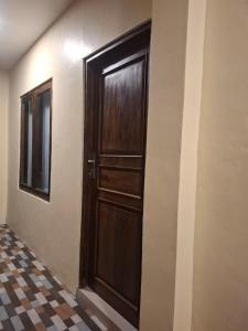 a wooden door in a room with a checkered floor at Waceno Umma in Ruteng