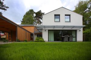 a white house with a green lawn at "Strandhus Finka" in Dierhagen