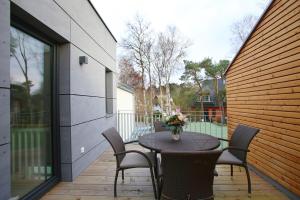 a table with chairs and a vase of flowers on a patio at "Strandhus Finka" in Dierhagen +17 photos