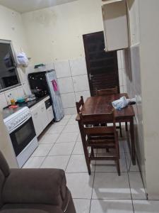 a kitchen with a table and chairs and a kitchen with a stove at Casa temporada soares in São José da Barra
