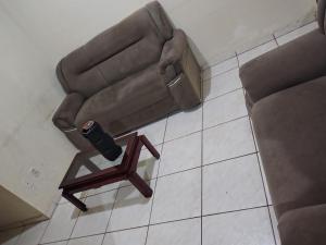 a brown couch and a wooden chair on the floor at Casa temporada soares in São José da Barra