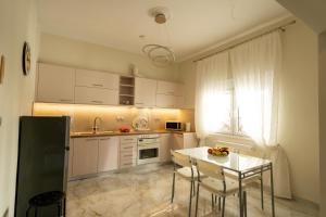 a kitchen with white cabinets and a table and a window at Meteora Rockside Lodge in Kalabaka