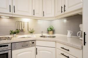 a kitchen with white cabinets and a sink at Haus Strandgeflüster Sandbank in Grömitz