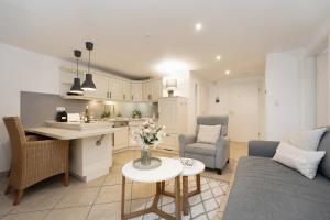 a kitchen and living room with a couch and a table at Haus Strandgeflüster Sandbank in Grömitz +14 photos