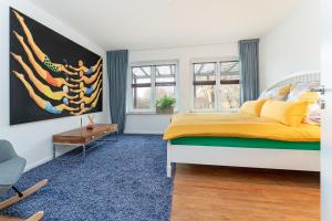 a bedroom with a bed with yellow sheets and a blue carpet at Ostseeschwimmerin in Schönberg