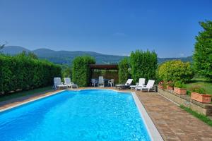 a swimming pool with chaise lounge chairs and a swimming pool at Holiday Home Casale Giulio by PosarelliVillas in Cetona