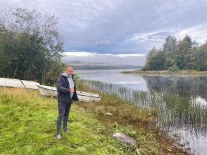 a man standing on the grass near a lake at Little Sven#s House in Mellansel +23 photos