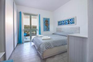 a white bedroom with a bed and a window at GuestHost - Gabbiano Lovely Flat with Veranda in Palau +27 photos