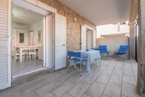 a patio with a table and chairs and a table at GuestHost - Gabbiano Lovely Flat with Veranda in Palau
