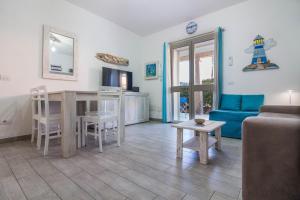 a living room with a table and a couch at GuestHost - Gabbiano Lovely Flat with Veranda in Palau
