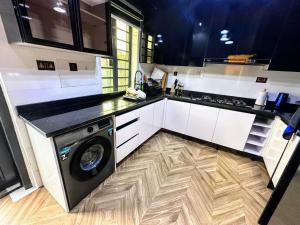 a kitchen with a washing machine on a wooden floor at Aquamarine Premium 5 Bedroom Duplex in Lagos in Lekki
