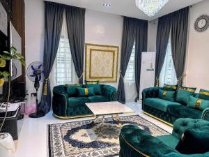 a living room with green couches and a table at Aquamarine Premium 5 Bedroom Duplex in Lagos in Lekki