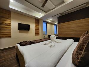 a bedroom with two beds and a flat screen tv at Arcadian Hotel in Gangtok