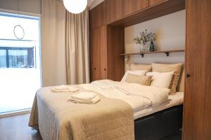 a bedroom with a large bed with two towels on it at Villa Memory-Aurora view bath-Sauna-Lapland-Santa in Rovaniemi