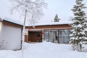 a house in the snow with a tree at Villa Memory-Aurora view bath-Sauna-Lapland-Santa in Rovaniemi