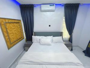 a bedroom with a large white bed and a window at Aquamarine Premium 5 Bedroom Duplex in Lagos in Lekki