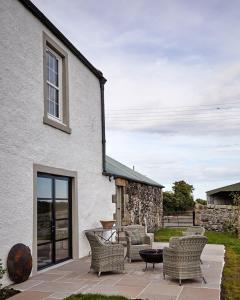 a patio with chairs and a table in front of a building at Banchory Farm in Fife