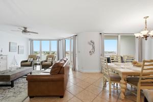 a dining room and living room with a table and chairs at SeaSpray Riverside 712 in Perdido Key