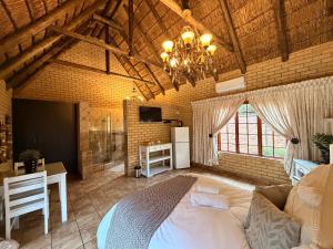 a bedroom with a bed and a table and a chandelier at Accommodation At Thabong in Brakpan