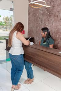 a woman is standing at a cash register at Pousada Carnaúbas - Sobral in Sobral