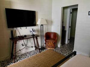 a hotel room with a television and a chair at Lodge 2 on the Mason TX square in Mason