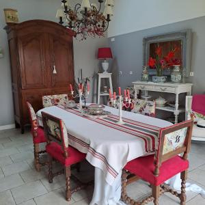 a dining room with a white table with red chairs at la guichardaye in Tréal +18 photos