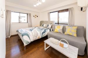 ein Wohnzimmer mit Sofa und Bett in der Unterkunft sakura 501 in Tokio