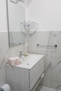 a white bathroom with a sink and a mirror at Renna's in Grammichele +15 photos