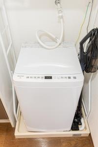 eine weiße Maschine, die in einem Zimmer auf einem Regal steht in der Unterkunft sakura 501 in Tokio