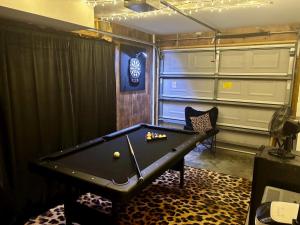 a room with a pool table and a chair at Happy Hours in Carolina Beach