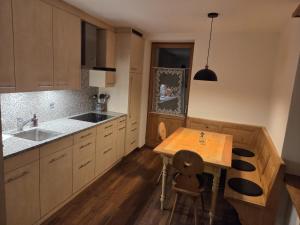 a kitchen with a wooden table and a sink at Chasa Bellavista in Ardez