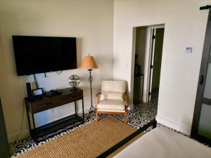 a living room with a tv and a chair and a table at Lodge 3 on the Mason TX Square in Mason