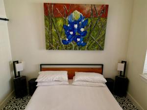 a bedroom with a bed with a painting on the wall at Lodge 3 on the Mason TX Square in Mason