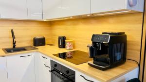 Eine Küche mit einer Kaffeemaschine auf der Arbeitsfläche in der Unterkunft Bydgoszcz GOLD 7 z sypialnią in Bydgoszcz