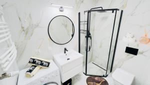 ein weißes Badezimmer mit Waschbecken und Spiegel in der Unterkunft Bydgoszcz GOLD 7 z sypialnią in Bydgoszcz + 11 Fotos