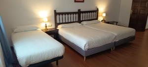 two beds sitting next to each other in a bedroom at Hotel Conde Rodrigo II by eme hoteles in Ciudad-Rodrigo